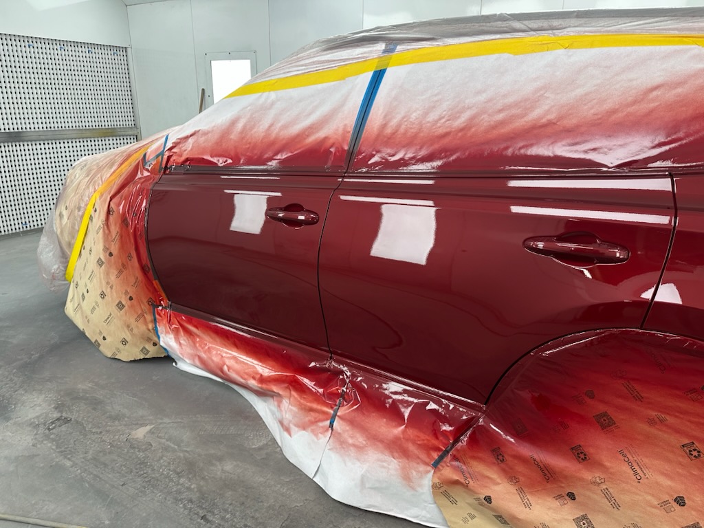 A red car masked off in the RT Auto paint booth